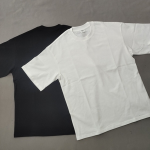 One black and one white heavyweight cotton t-shirt with a relaxed boxy cut, laid flat