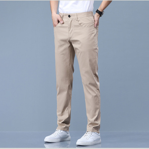 Khaki cotton chino trousers with a straight leg, worn with white trainers